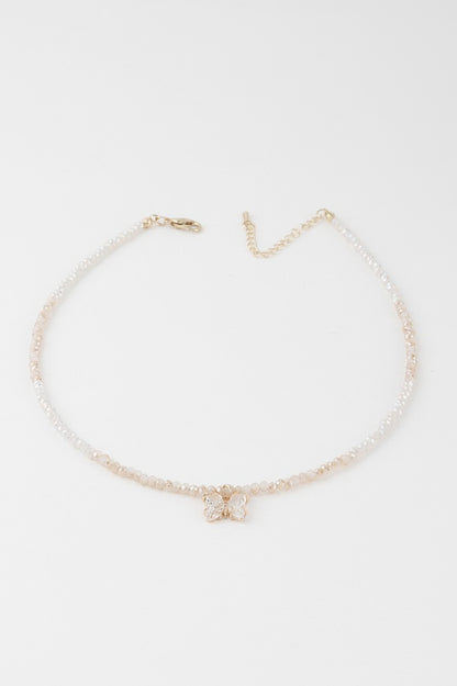 A gold white colored crystal butterfly beaded necklace.