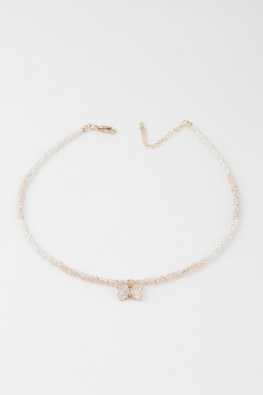 A gold white colored crystal butterfly beaded necklace.