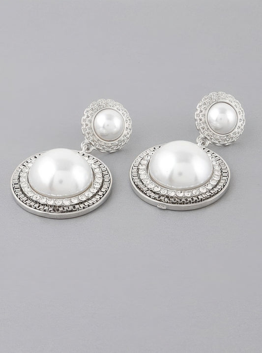 A pair of silver cream colored double framed pearl drop earrings.