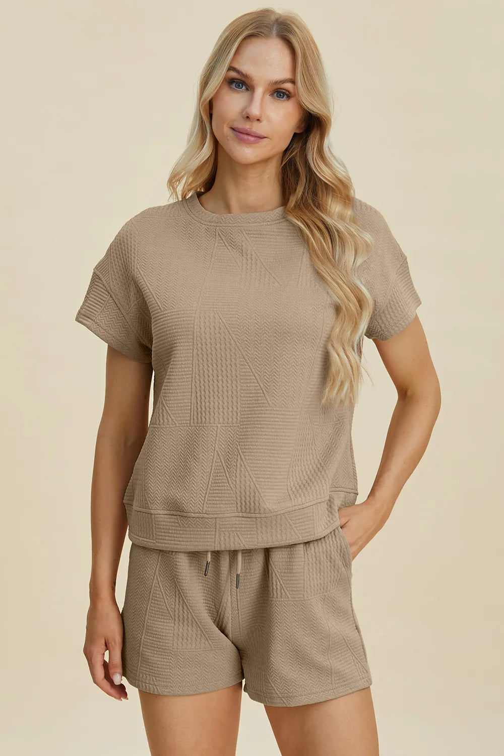 A woman posing in a khaki textured short sleeve top and shorts set.