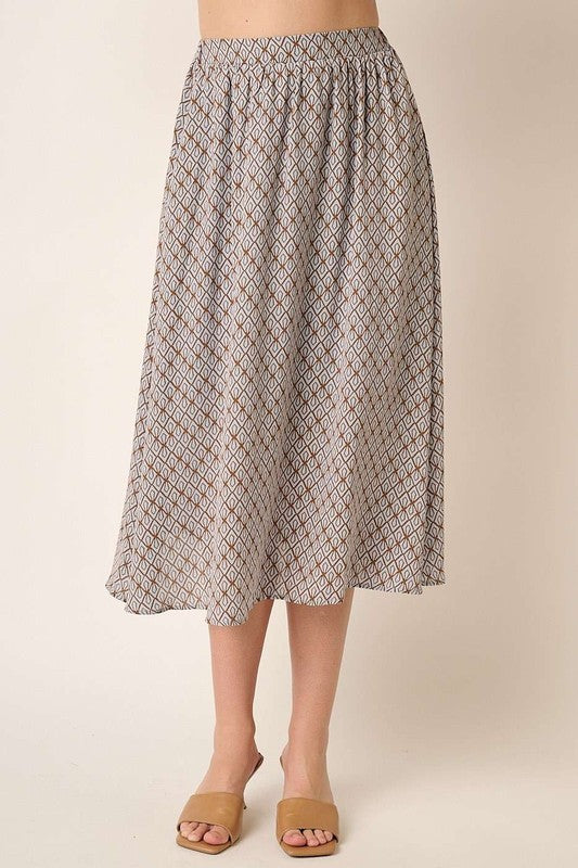 A woman posing in a taupe printed midi skirt.