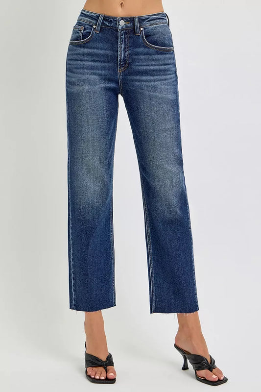 A woman posing in dark wash high-rise slim barrel jeans.
