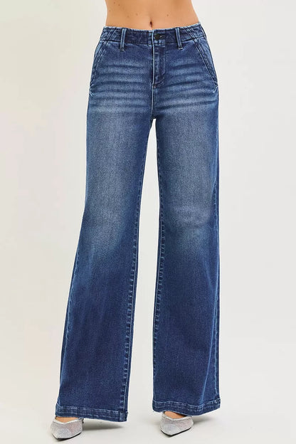 A woman posing in dark wash high-rise wide-leg slanted pocket jeans.
