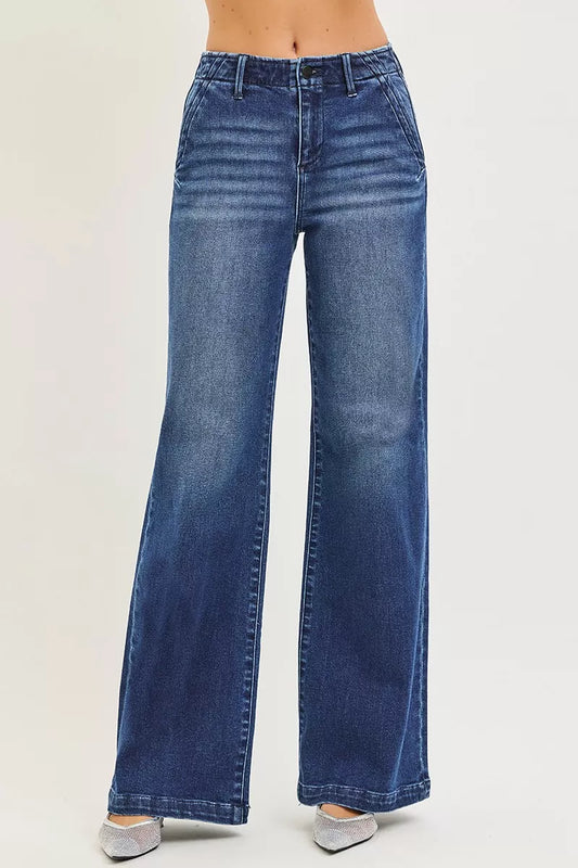 A woman posing in dark wash high-rise wide-leg slanted pocket jeans.