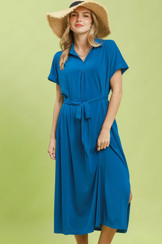 A woman posing in a cerulean blue belted collar midi dress.