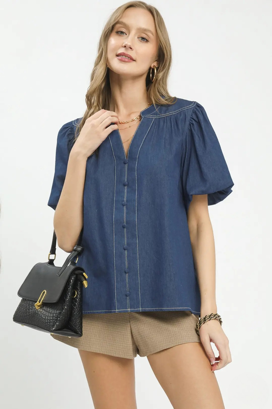A woman wearing a dark wash denim button-front puff sleeve boho blouse.