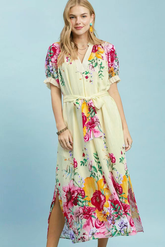 A woman posing in an ecru floral border print midi dress.