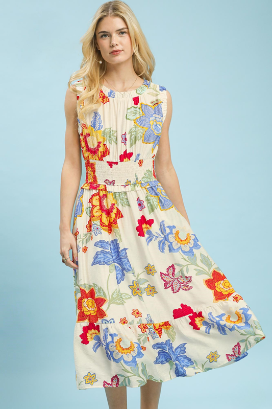A woman posing in a cream-colored floral smocked midi dress.