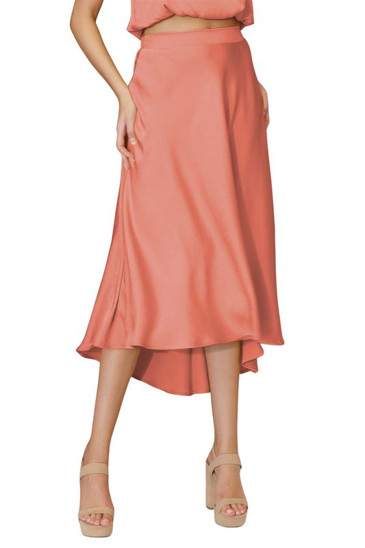 A woman posing in a peach pink washed poly silk midi swing skirt.