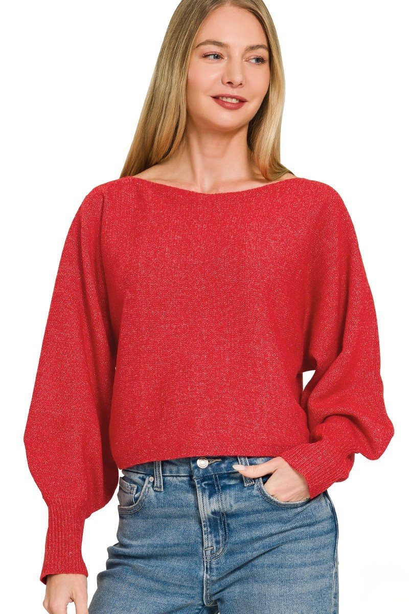A woman posing in a ruby red boat neck balloon sleeve sweater.