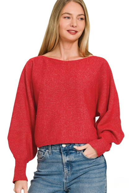 A woman posing in a ruby red boat neck balloon sleeve sweater.