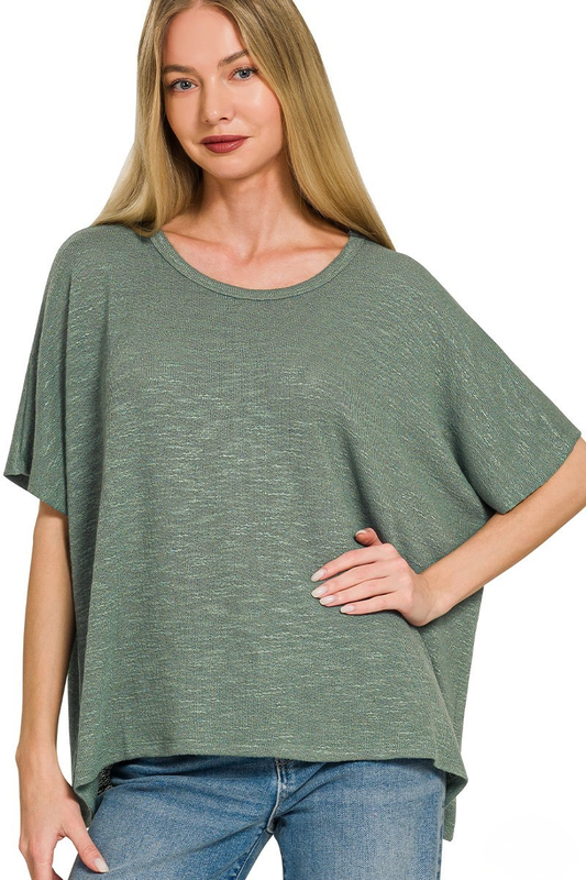 A woman posing in an ash jade colored slub oversized hacci top.