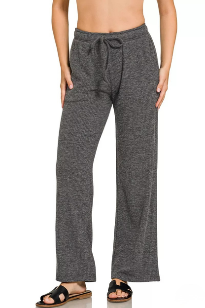 A woman posing in black ribbed drawstring lounge pants.