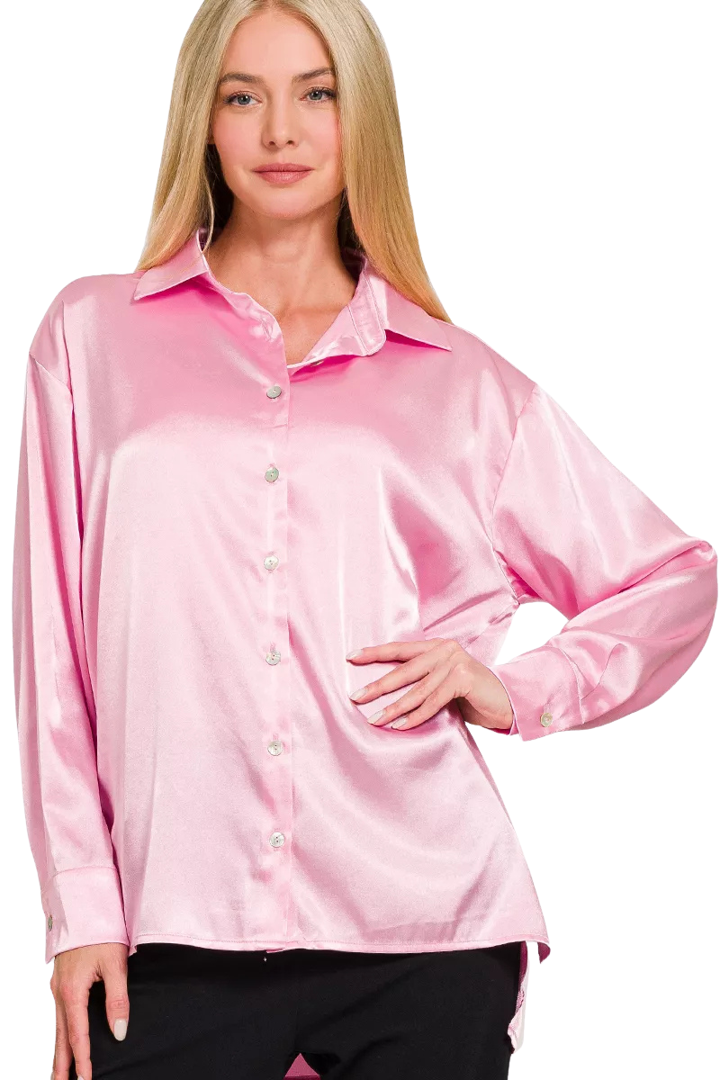 A woman posing in a pink satin button-front long sleeve shirt.