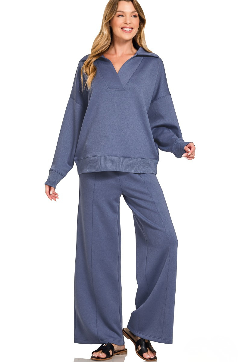 A woman posing in a blue indigo scuba fabric collar pullover and center seam pants set.