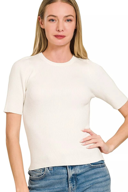A woman posing in an ivory-colored viscose ribbed short sleeve sweater.