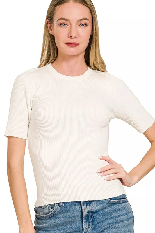 A woman posing in an ivory-colored viscose ribbed short sleeve sweater.