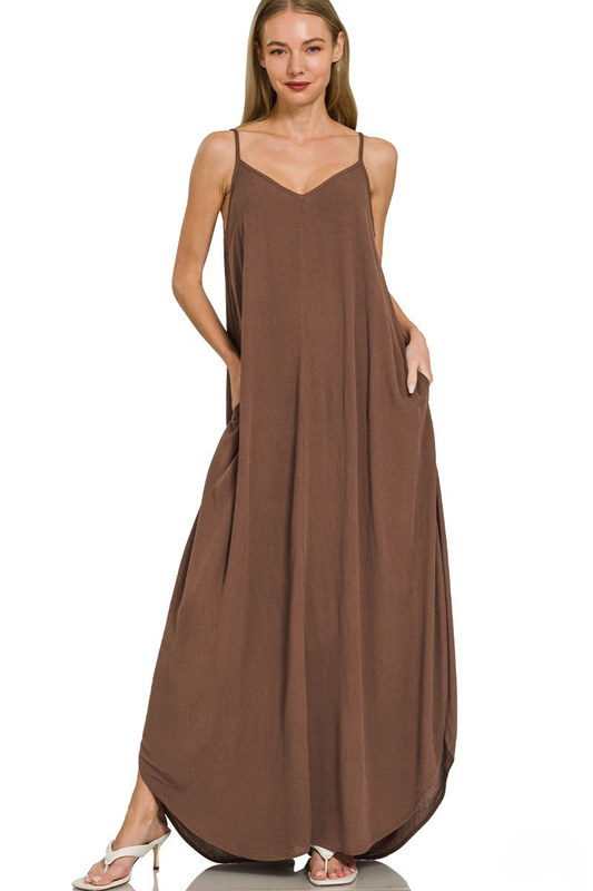A woman posing in a brown woven crinkle cami pocket maxi dress.
