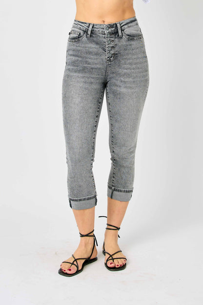 A woman posing in gray high-waisted capris.