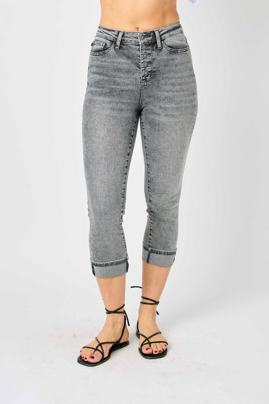 A woman posing in gray high-waisted capris.
